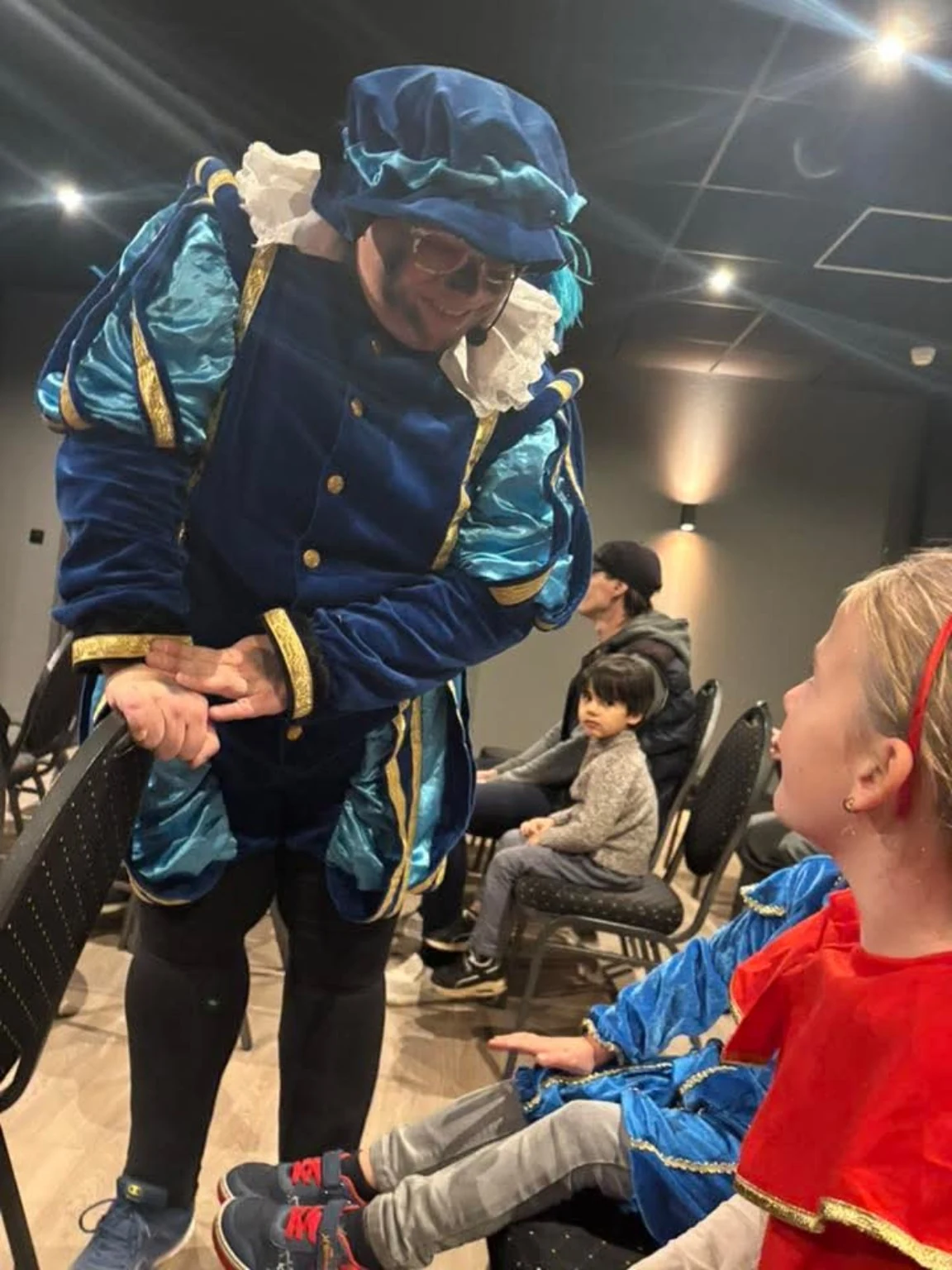 Goochelpiet maakt contact met een kind tijdens een Sinterklaasactiviteit