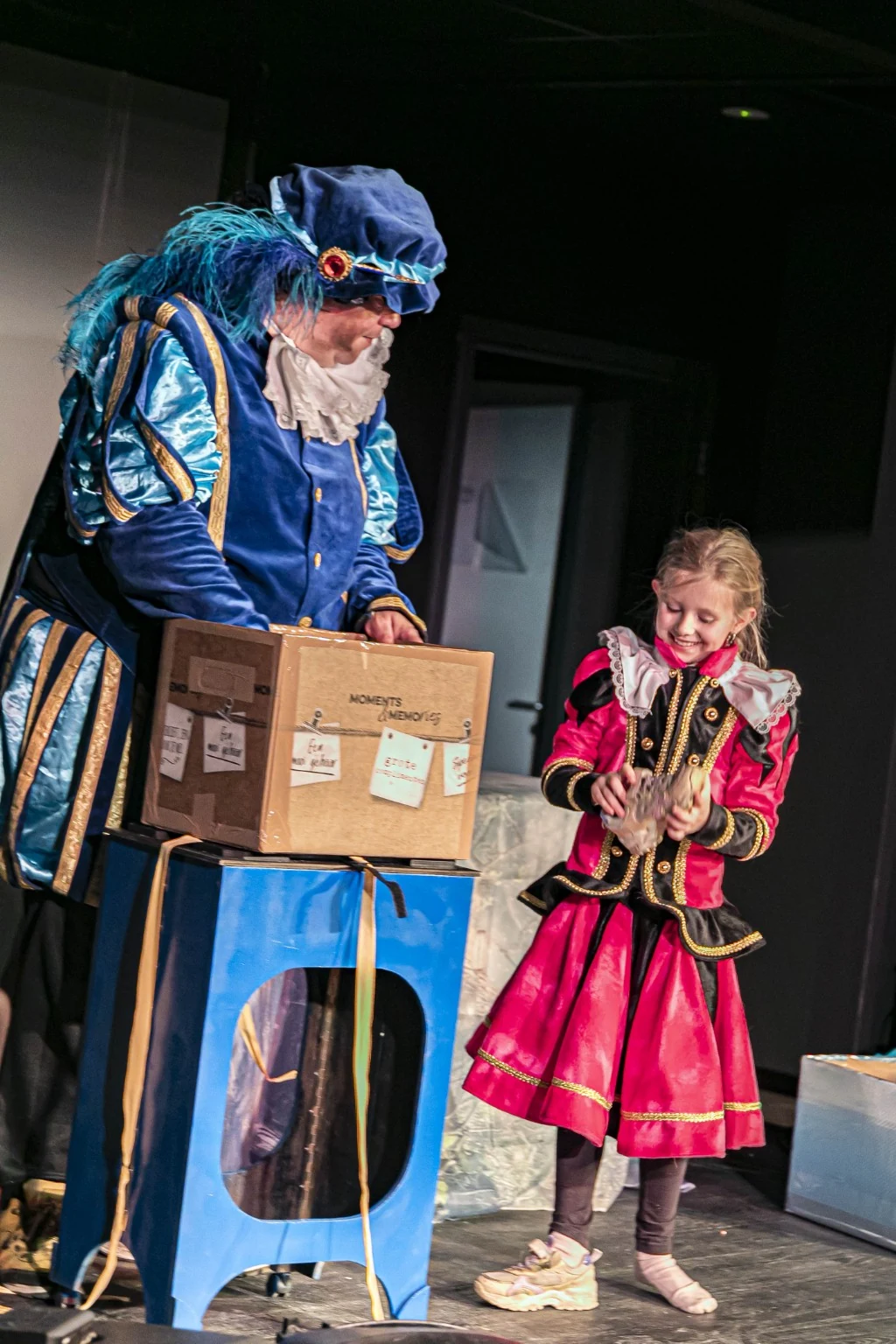 Kind helpt goochelpiet op het podium tijdens een Sinterklaasshow