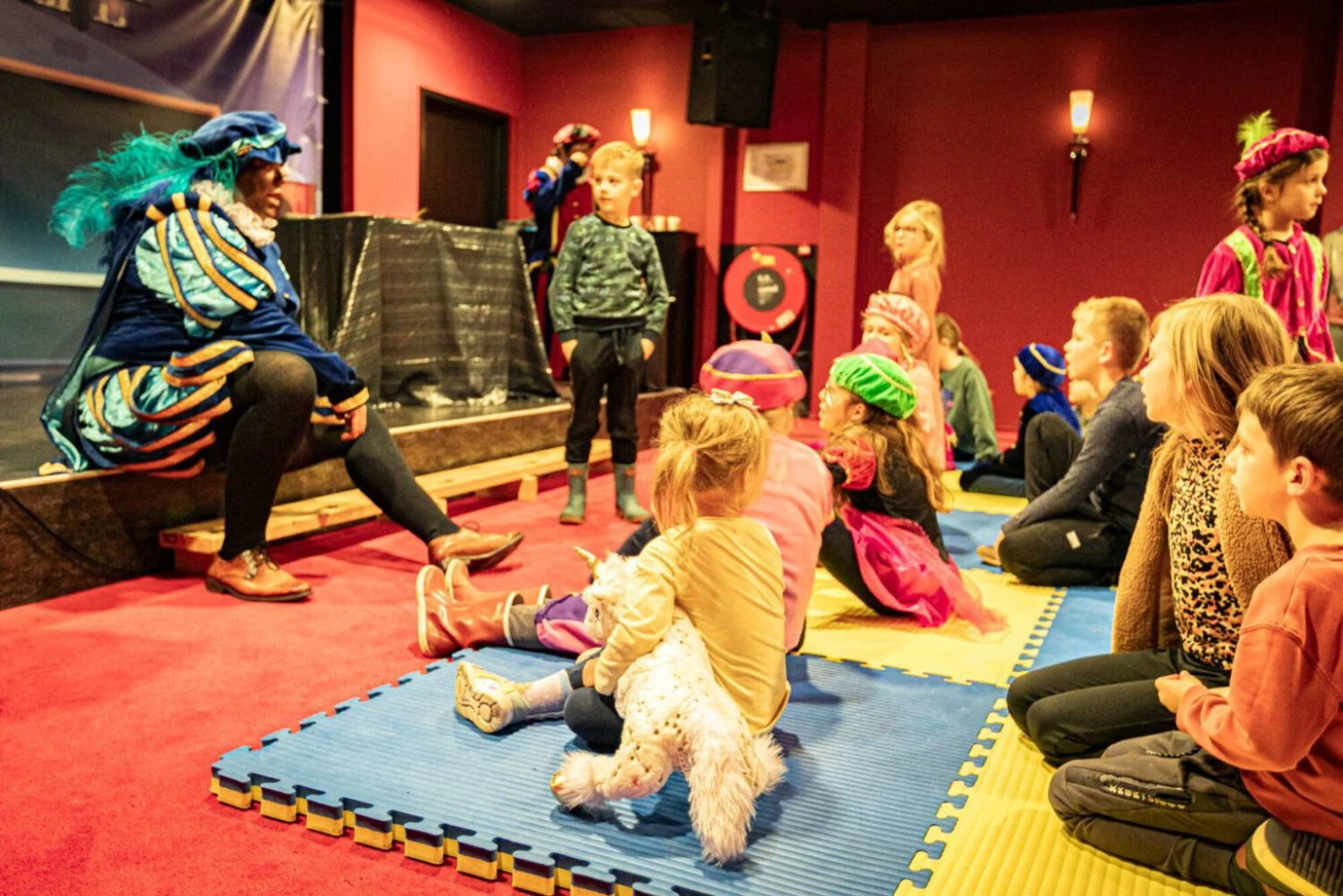 Kinderen zitten voor het podium tijdens een Sinterklaasshow